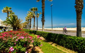 A guest rides a bicycle along the beachside boardwalk in Valencia, Spain.